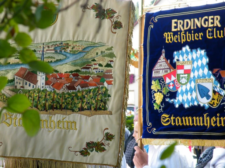 a person holds up a tapestry depicting the state of vermont