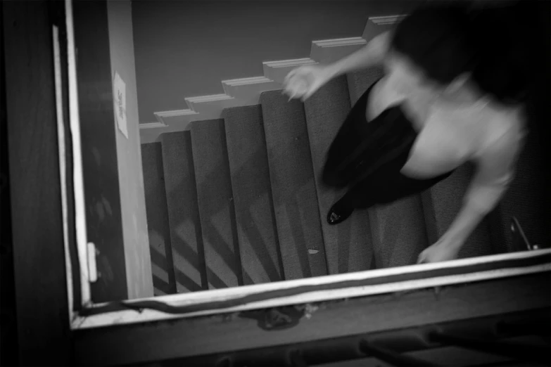 a man walking up a staircase in black and white