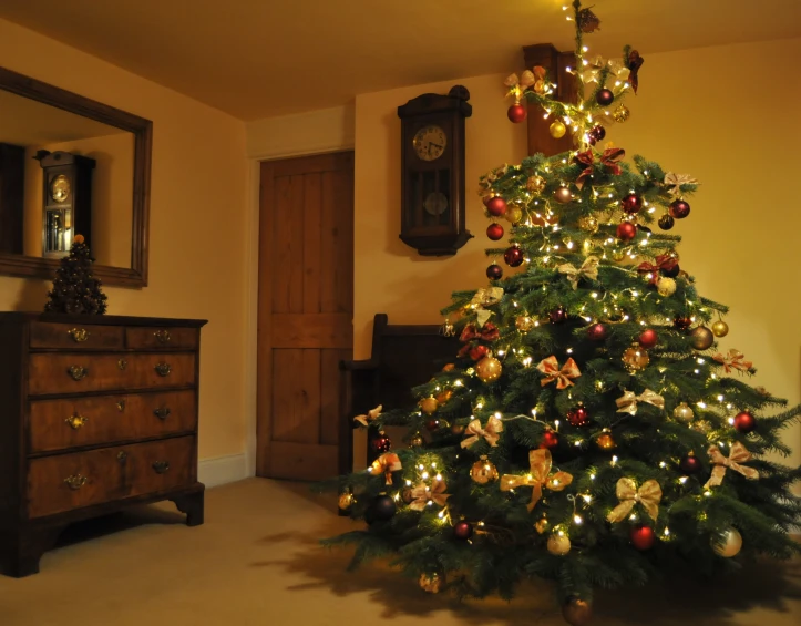 a lighted christmas tree in the corner of a room