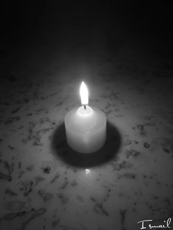 a lit candle is on a marble counter