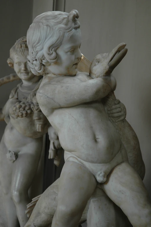 a sculpture of two children one holding a bird and the other carrying a fish