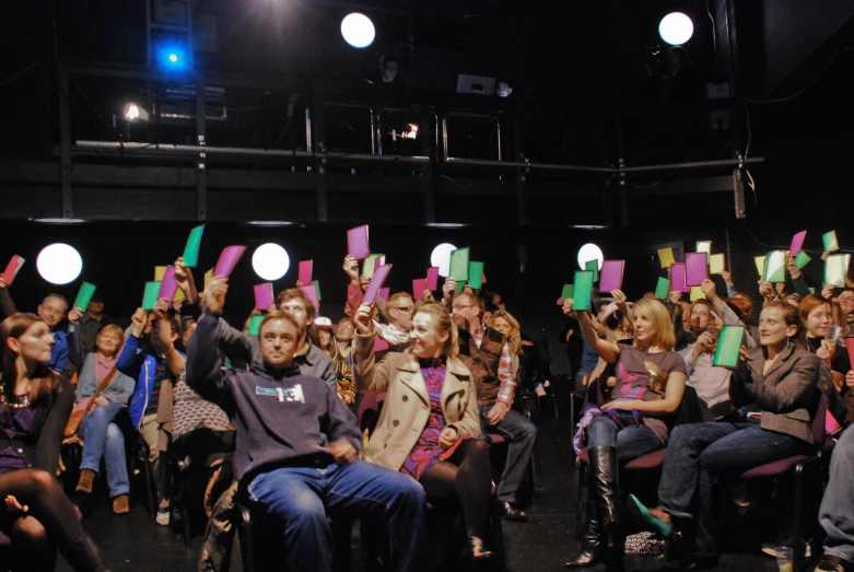 people on a stage at an audience with signs