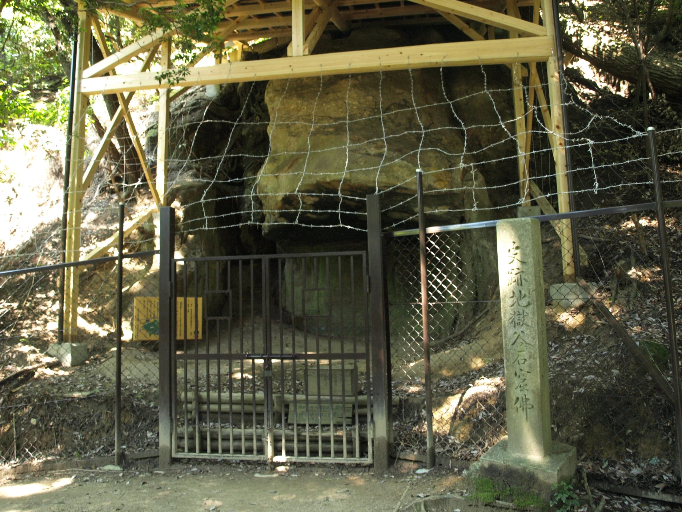 a metal gate around an outdoor shrine