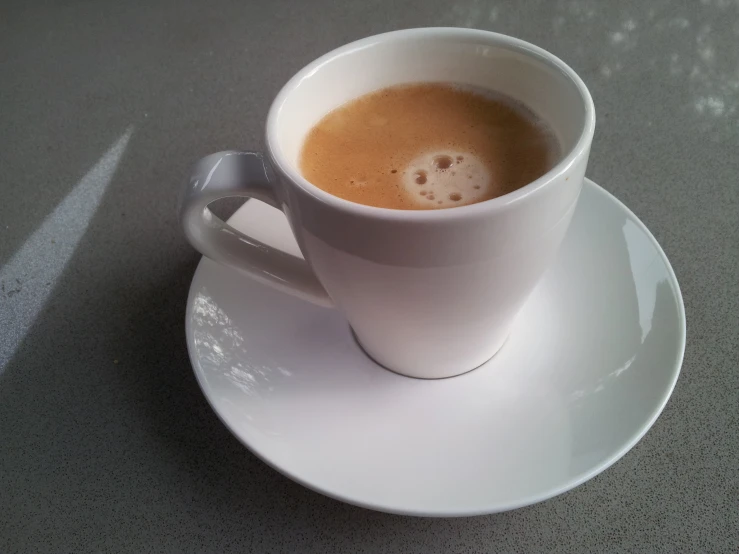 a white cup filled with coffee on top of a saucer