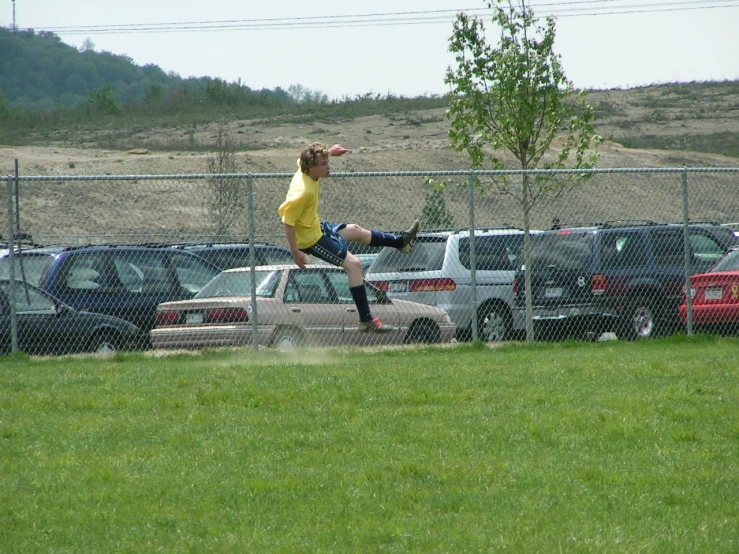 a young man is kicking a soccer ball on the field