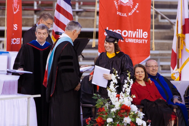 several people are at the commencement ceremony of a graduate