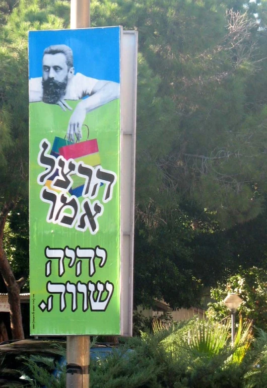 a green sign with hebrew characters and a male