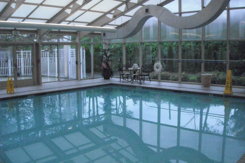 large indoor swimming pool in residential building with glass walls