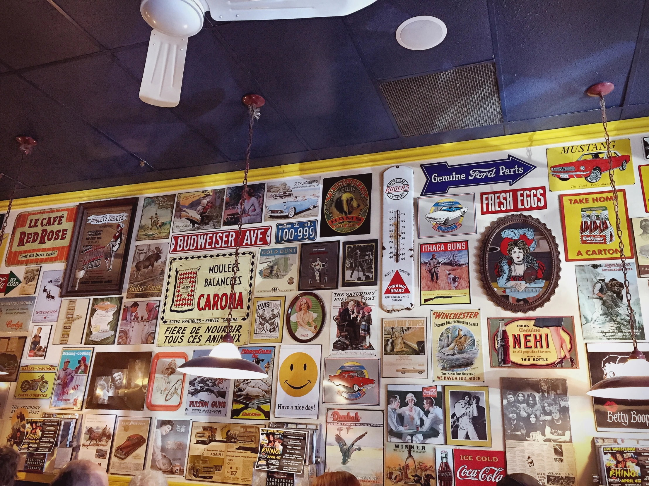 a wall covered in posters and flyers sitting below a ceiling