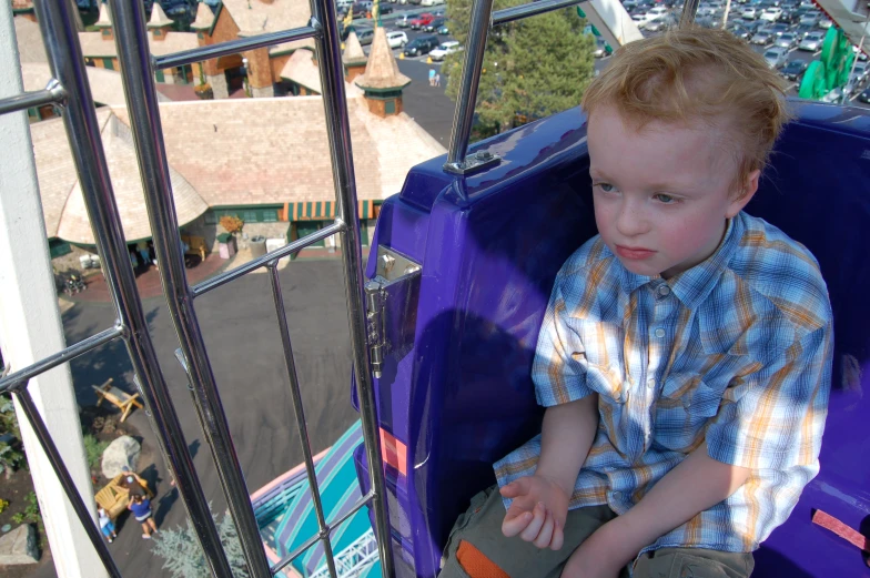 a small boy riding in a colorful seat on a ride