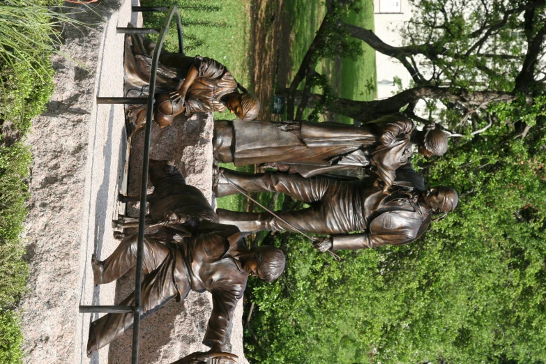 a statue in front of a park with four statues