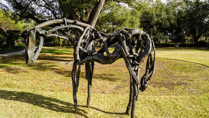 a metal sculpture of leaves in a grass field