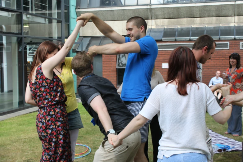 a group of people standing outside holding their hands together