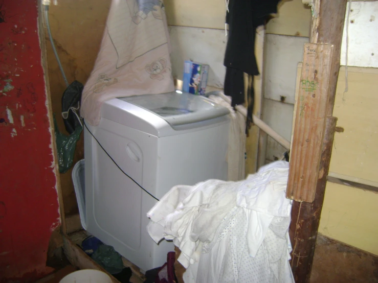 a laundry room with a washing machine and a small bag on the floor