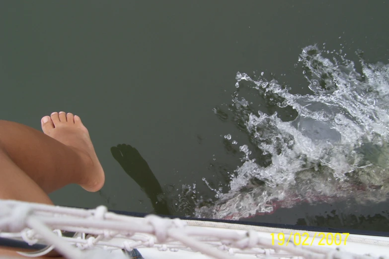 feet sticking out from inside boat on water