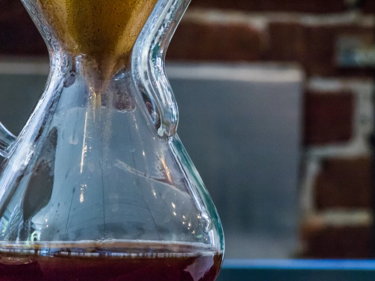 a glass jug is filled with liquid on top of a table