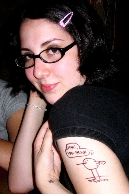 a girl with glasses with a bird on her arm