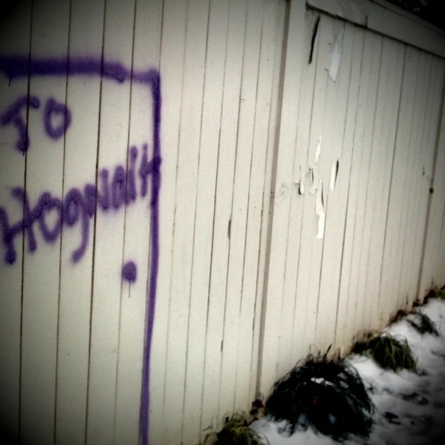 a purple marker on a white wall near a pile of snow