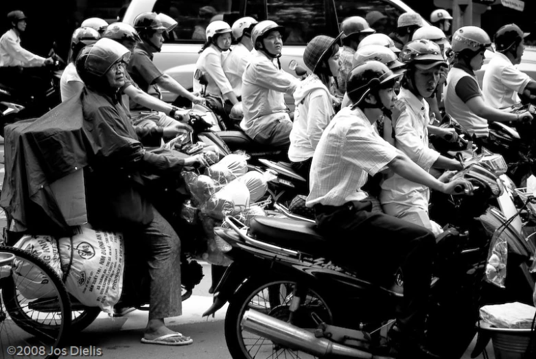 a group of people riding motorcycles down a city street