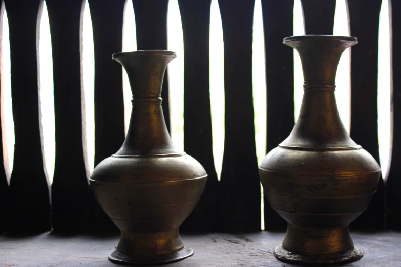 a couple of vases that are sitting in front of a window