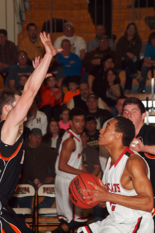 two men playing basketball in front of spectators