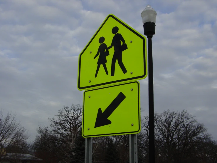 a yellow crossing sign showing people crossing on it