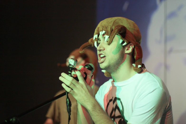 a man wearing a deer helmet while playing a game with his cell phone