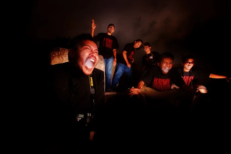 a group of men singing on stage with smoke in the background