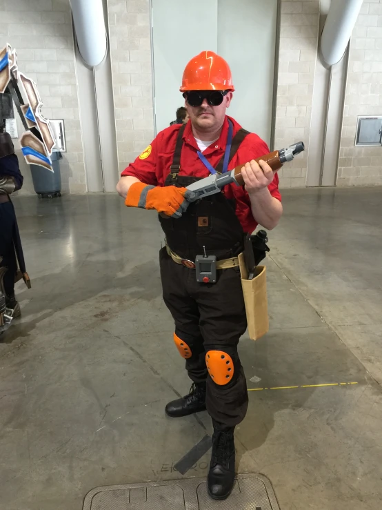 the man dressed as a fireman holds a gun