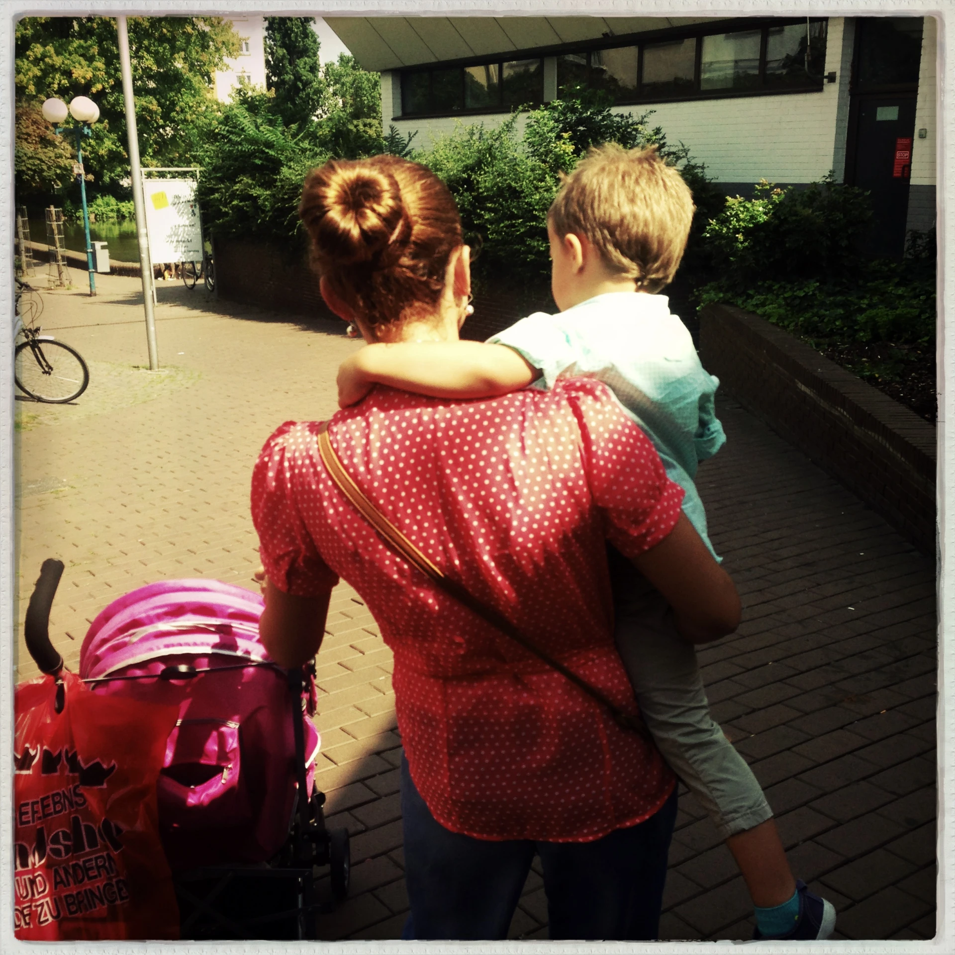 two children walking down a sidewalk while carrying suitcases