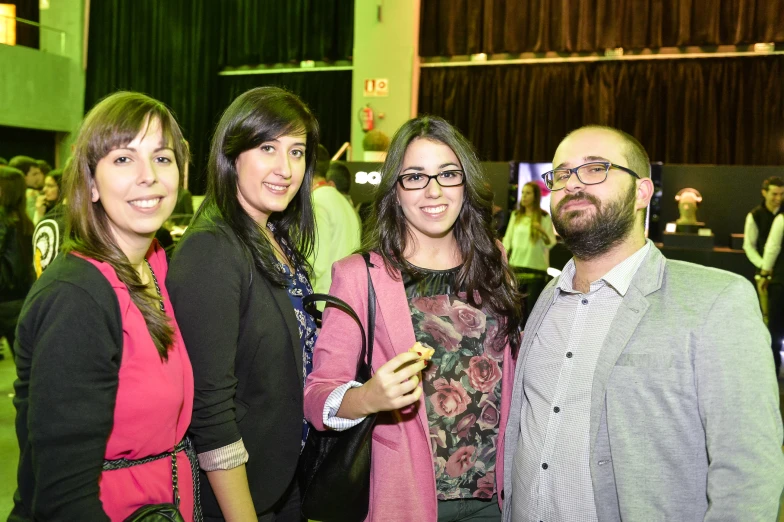 three women and one man posing for a po