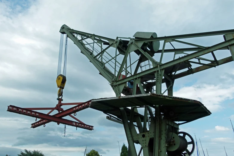 a very large crane with some people hanging off of it