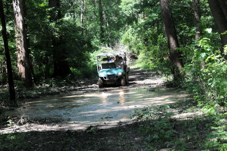 the jeep is driving down the muddy road