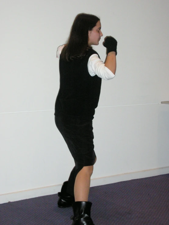 a girl standing in a white and black outfit, with a baseball glove