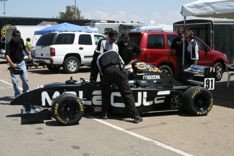 men sitting in a racing car on the street