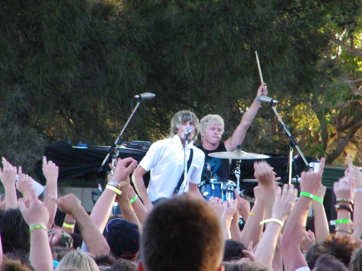 two men on the stage with arms in the air