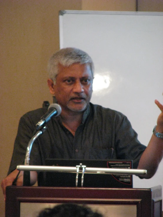 man standing behind a podium giving a presentation