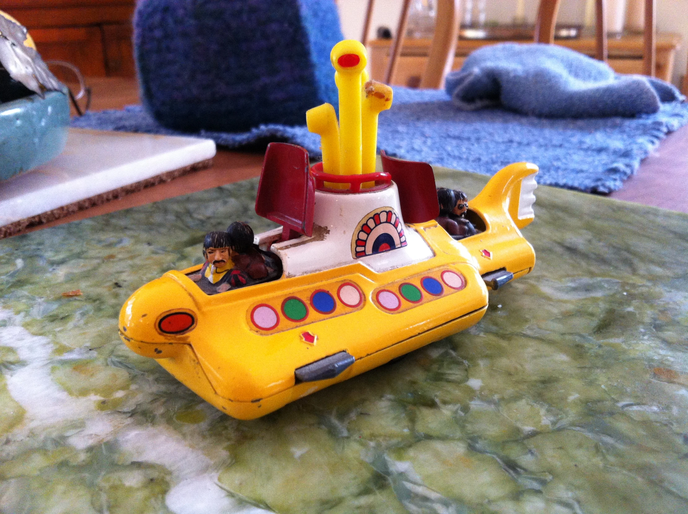 a yellow submarine toy sitting on top of a table