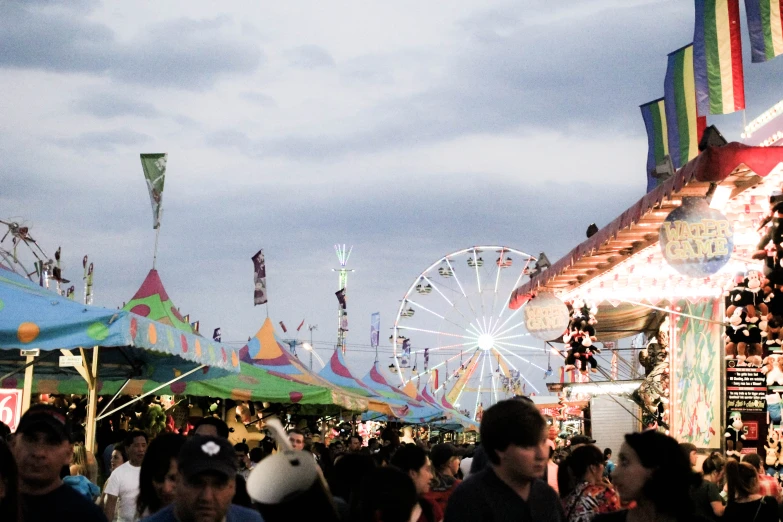 people walking around a carnival with their fair goers