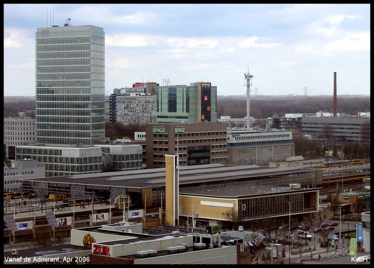 a big building sitting next to a city with some buildings in the background