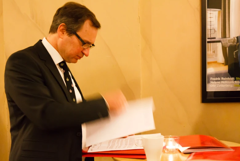 man in suit reading a book about business