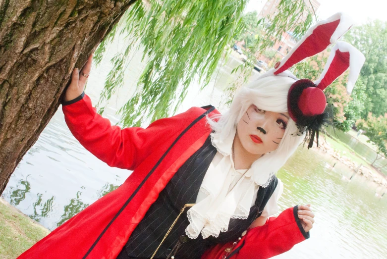 a woman in a red and black costume near a tree