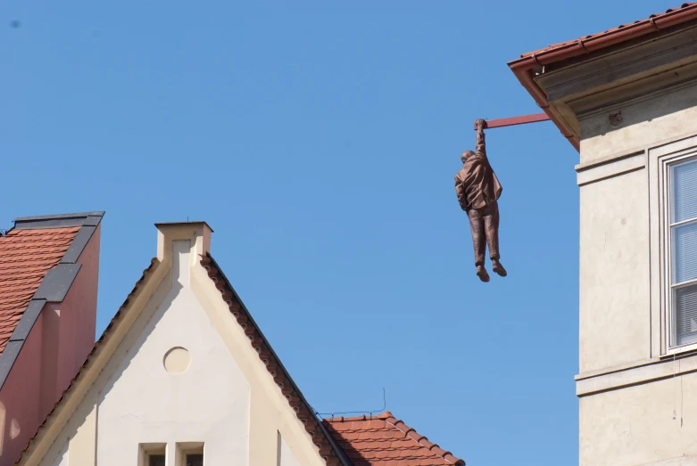 a man is hanging upside down on the outside ladder above an old brick building