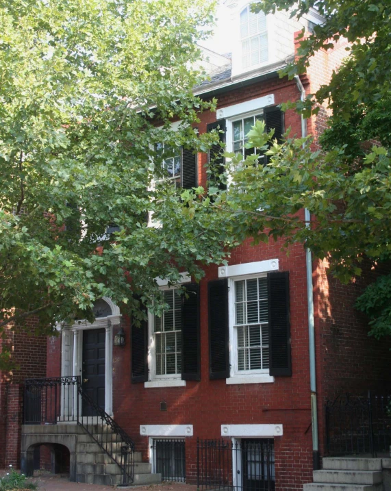 a building with black shutters and a fire hydrant