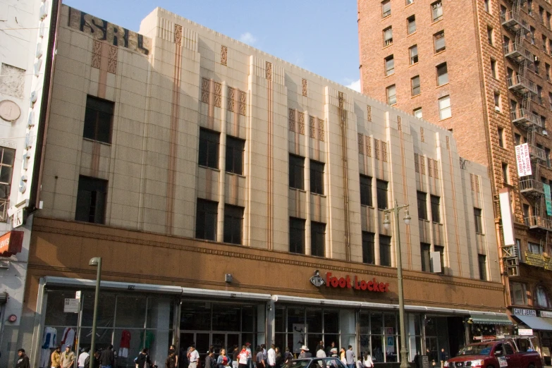 people are walking along the sidewalk in front of the building