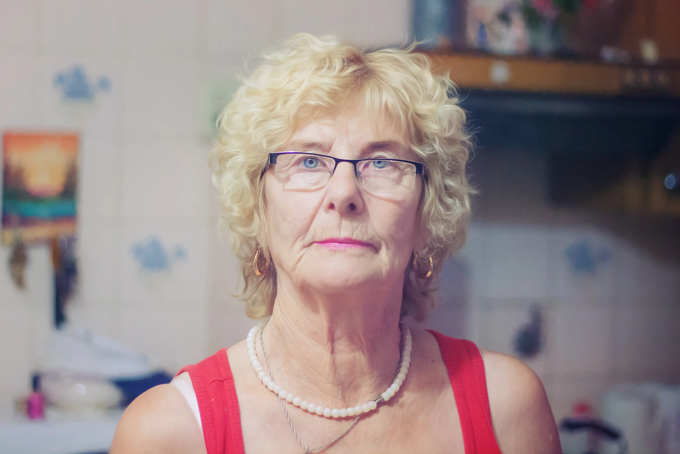 an older woman wearing glasses, necklace and beaded necklace