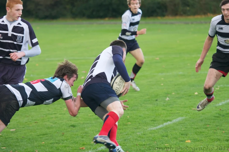 two teams playing a rugby match in the grass