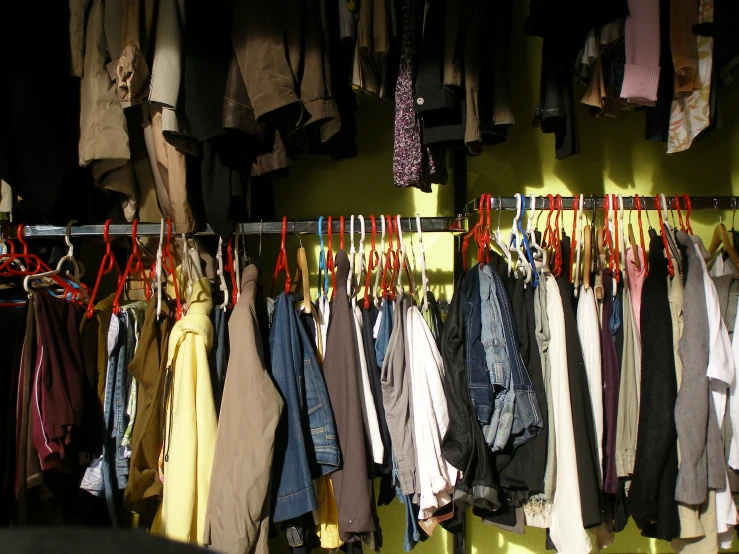 there is a rack with different jackets and tie ties
