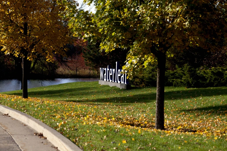 park with trees and a sign with writing on it