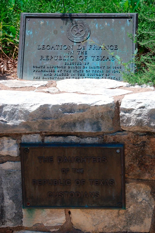 a plaque on the edge of a large rock wall